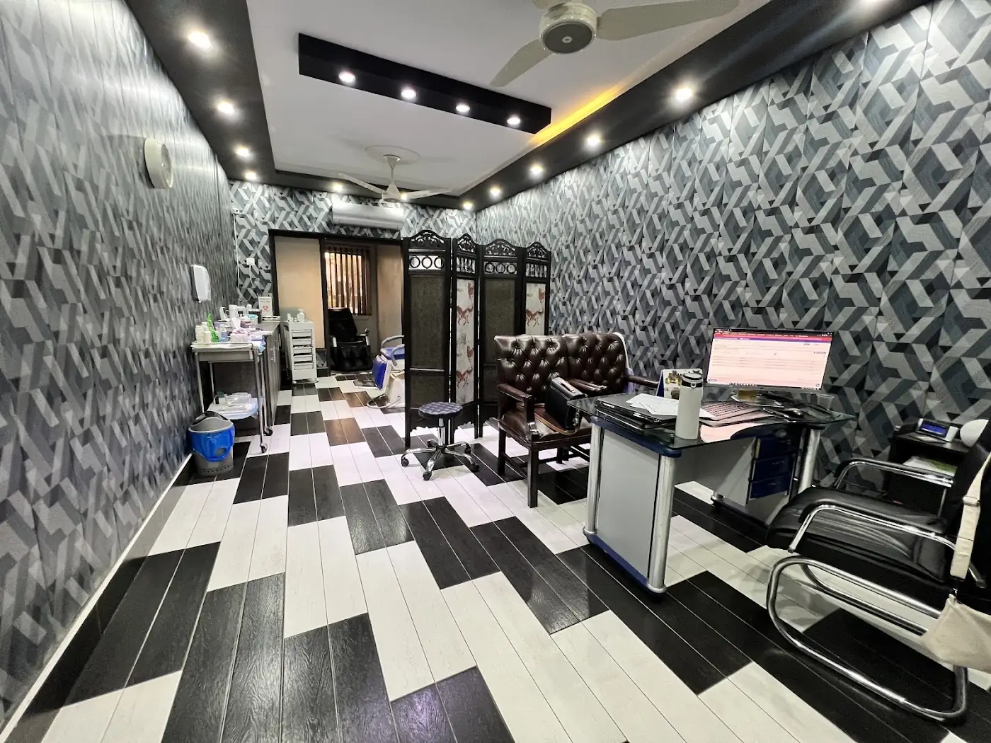 Treatment area at Dr Kashif's Aesthetic Studio with geometric walls and a black and white floor